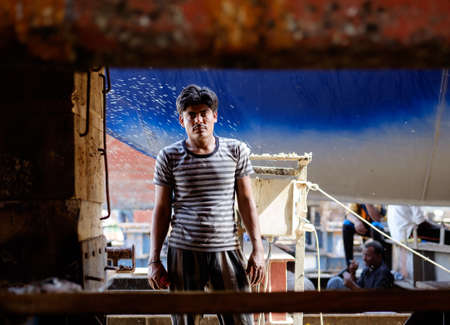 Indian and Bengali Workers repairing old wooden ships and Dhows cruise in Dubai, UAE on 13.10.2014のeditorial素材