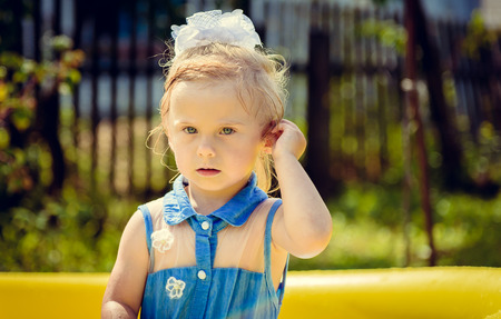 A little wet girl in an inflatable outdoor swimming poolの写真素材