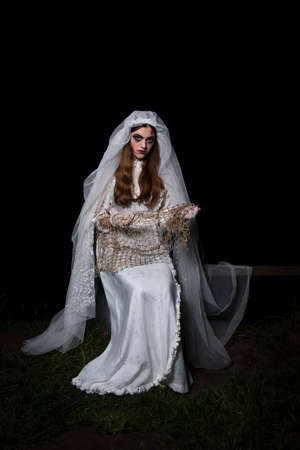 Creepy dead bride at night in a swamp. Halloween sceneの写真素材