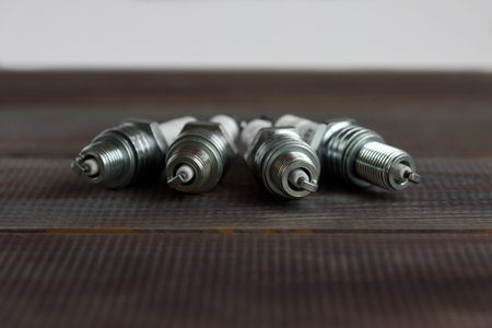 Car spark plugs on wooden table.Spare parts for the car.