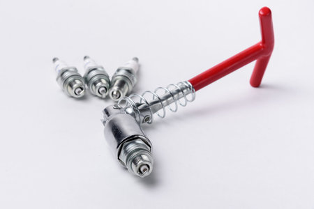 Car spark plugs and key on white background. Car spare parts.