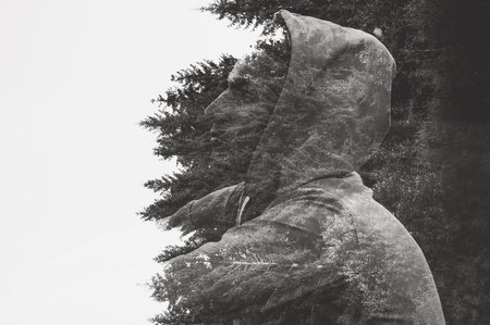 Portrait of a pensive guy against a background of trees, double exposure.