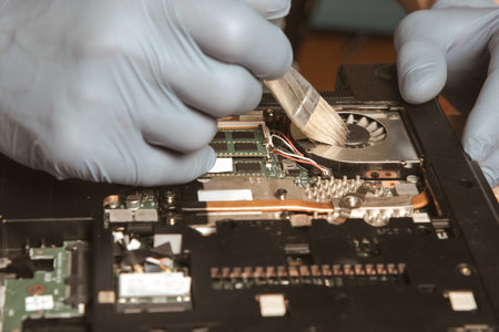 Laptop repair. Dust cleaning. An engineer cleans a computer.