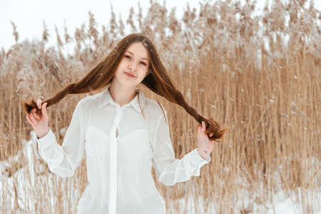 Young girl in a blouse in the park in winter.の写真素材