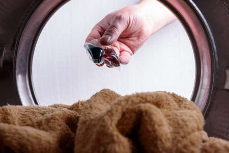 Gel capsule for a washing machine. In the hands of throwing in a drum.の写真素材