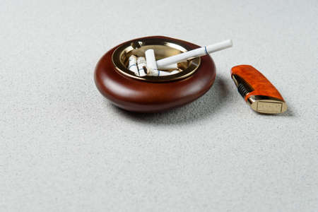 Stylish exquisite ashtray with cigarette and lighter on the tableの写真素材