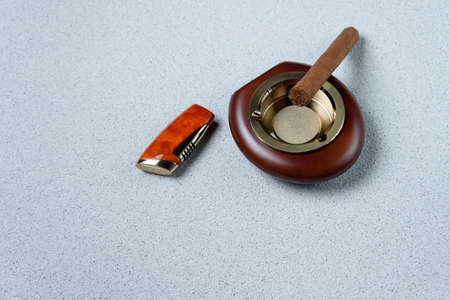 Stylish exquisite ashtray with cigarette and lighter on the tableの写真素材