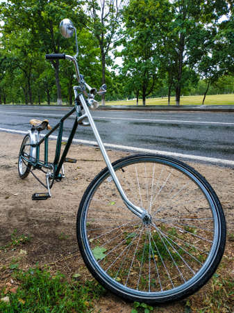 Bicycle parked at the side of the park road after the rainの写真素材