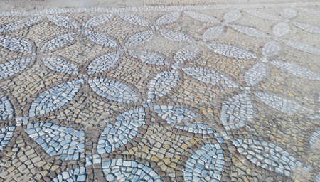 Ancient mosaic covering the ground laid out with pieces of stones in a neat patternの写真素材