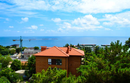 Construction of new buildings and hotels in summer in a resort town near the sea and a view from the window of a crane and new housesの写真素材