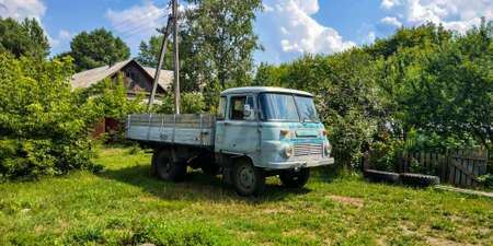 Old retro vintage truck is parked near a house in a village in the countrysideの写真素材