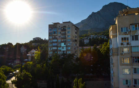 High-rise buildings and holiday houses of a mountain resort town with steep roads under the scorching southern sunの写真素材