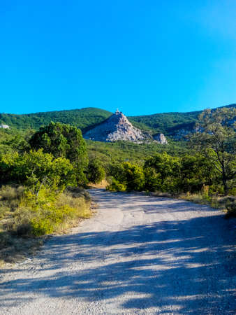 Long road along a mountain serpentine among tropical trees on a hot southern day on the way to the mountain churchの写真素材
