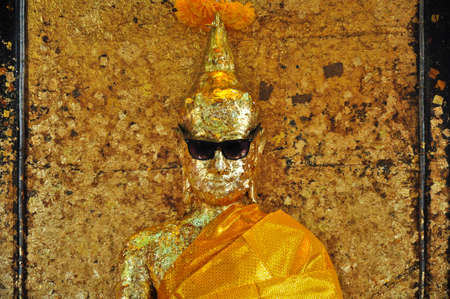 Strange image of Buddha wears sunglasses in Thailandの写真素材