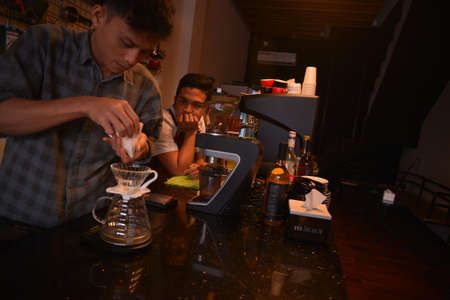 TENGGARONG, INDONESIA - MEI 2017 : Handsome barista cafe coffee preparing cup and making of coffee Service Concept for customer in coffee shop.のeditorial素材