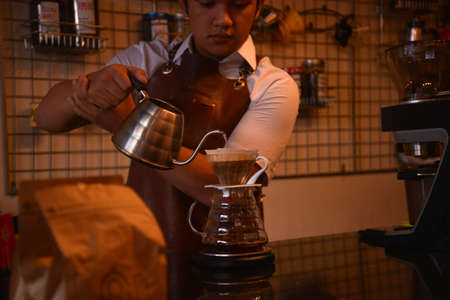 TENGGARONG, INDONESIA - MEI 2017 : Handsome barista cafe coffee preparing cup and making of coffee Service Concept for customer in coffee shop.のeditorial素材