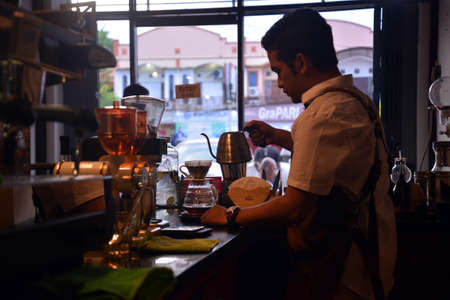 TENGGARONG, INDONESIA - MEI 2017 : Handsome barista cafe coffee preparing cup and making of coffee Service Concept for customer in coffee shop.のeditorial素材
