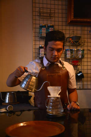 TENGGARONG, INDONESIA - MEI 2017 : Handsome barista cafe coffee preparing cup and making of coffee Service Concept for customer in coffee shop.のeditorial素材