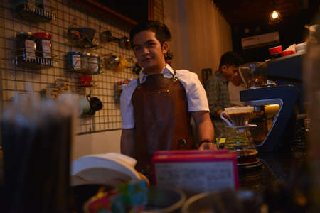 TENGGARONG, INDONESIA - MEI 2017 : Handsome barista cafe coffee preparing cup and making of coffee Service Concept for customer in coffee shop.のeditorial素材