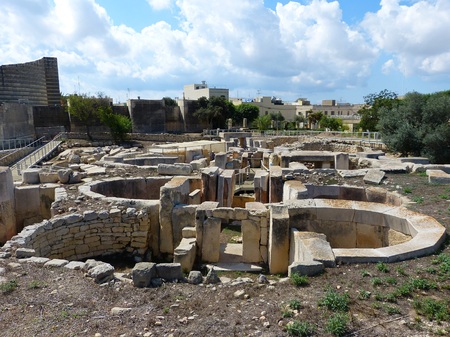 Tarxien, Malta - September 23, 2013. Megalithic structures of the Tarxien Temples with neolithic megaliths, walkways and residential buildigs in the background.のeditorial素材