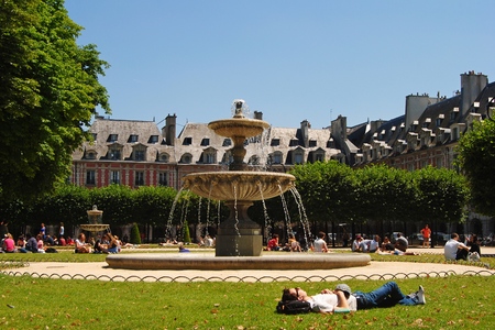 Paris, France - July 2, 2014. North-East part of Place des Vosges square in Paris, with grass lawn, fountain and people.のeditorial素材