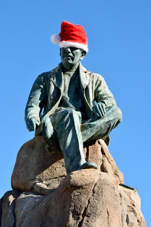 Monterey, California, United States of America - November 29, 2017. Sculpture of American writer John Steinbeck, as part of the Cannery Row monument in Monterey, wearing a Christmas holiday hat.のeditorial素材