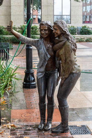 Sugar Land, Texas, United States of America - January 16, 2017. Statue of two girls posing for a selfie photo on Town Square in Sugar Land, TX.のeditorial素材