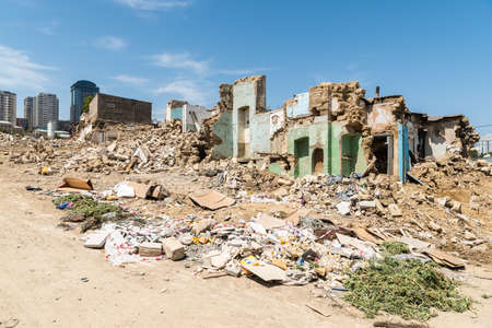 Baku, Azerbaijan - May 9, 2019. Demolished buildings around Sovetskaya Street in Baku, with modern buildings in the background.のeditorial素材