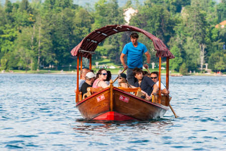 Bled, Slovenia â July 5, 2019. Slovenian wooden boat pletna carrying tourists to Bled Island.のeditorial素材