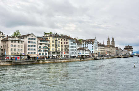 Zurich, Switzerland â June 25, 2016. View of Old Town buildings along the banks of Limmat River in Zurich, with commercial properties and people.のeditorial素材