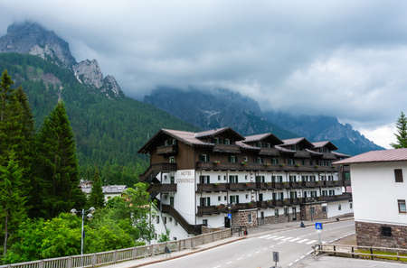 San Martino di Castrozza, Trentino, Italy â July 3, 2016. Street view in San Martino di Castrozza mountain resort in Italy, with Hotel Colfosco and the Dolomites in the background, on a foggy summer day.のeditorial素材