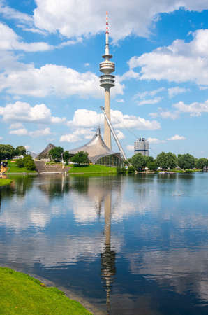 Munich, Germany â July 1, 2016. View of Olympic Tower (Olympiaturm) with reflections in  Olympiasee pond in Olympic park in Munich, Germany, on a sunny summer day, with clouds.のeditorial素材