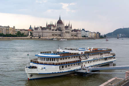 Budapest, Hungary â June 4, 2017. View of Danube river in Budapest, toward the Parliament building, with cruise boat in the foreground, at dusk.のeditorial素材