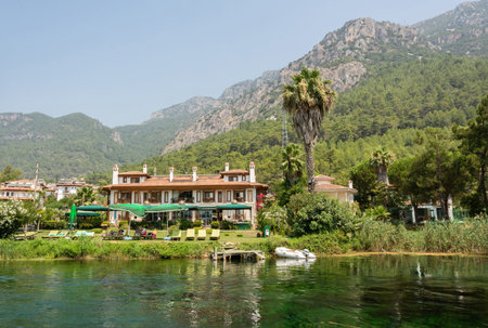 Akyaka, Mugla, Turkey - July 30, 2016. Azmak stream in Akyaka village in Mugla province of Turkey, with people and buildings.のeditorial素材