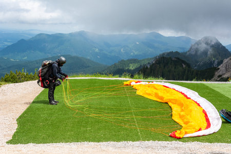 An unidentified paraglider preparing a launch in mountainous area near Fussen, Germany.のeditorial素材