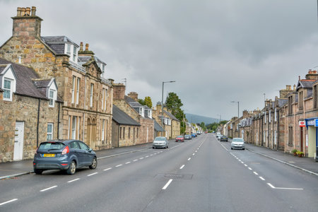 Aberlour, Scotland, United Kingdom â September 17, 2017. High Street in Aberlour, Scotland. Street view with historic buildings and cars, on a cloudy day.のeditorial素材