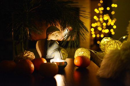Christmas still life with angel, candle, tangerines by the fireplace