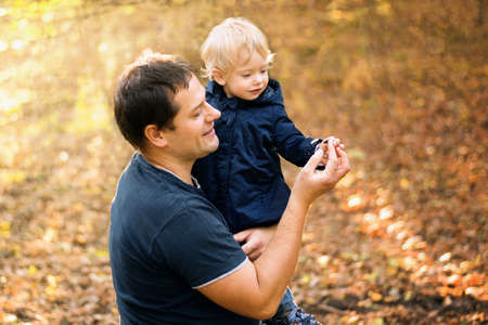Dad and daughter in the autumn park forestの写真素材