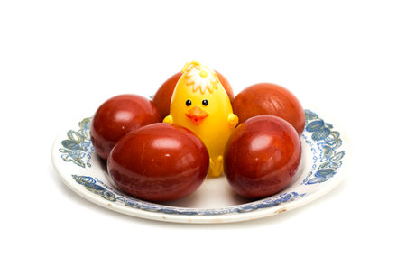 Happy Easter. Easter eggs on a plate with a yellow chicken. Photo.