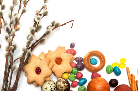 Happy Easter. Easter eggs, candy and cookies with a willow branch. Photo.