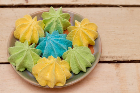 Sweet, crispy, multi-colored meringue in a plate.