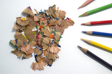 sawdust of several colored pencils on white background