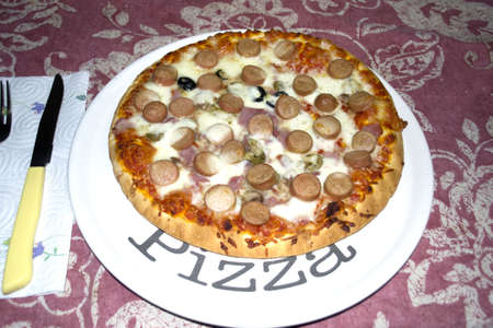pizza with hotdog and mushrooms on a plate with の写真素材