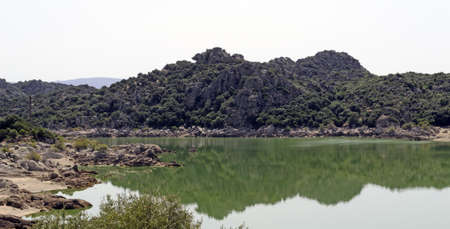 detail of Coghinas lake with a green hill reflected in the waterの写真素材