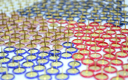 colored pushpins upside down in a random golden patternの写真素材