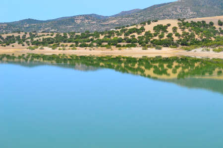 hill reflected in the water in Coghinas lake, Sardinia, Italyの写真素材