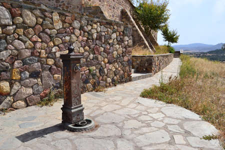 rusy fountain in front of a stone wallの写真素材
