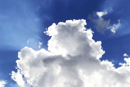 sun behind white clouds in a blue skyの写真素材