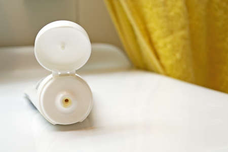 tube of hydrating cream on a sink with a yellow towel in the backgroundの写真素材