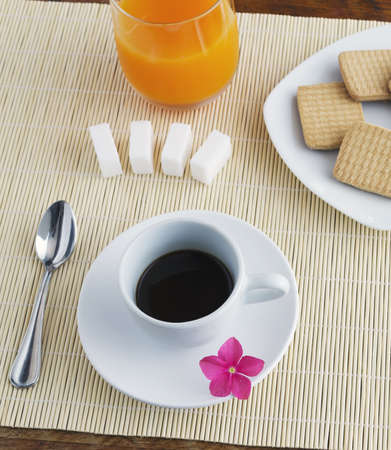 cup of coffee and glass of juice on a place matの写真素材
